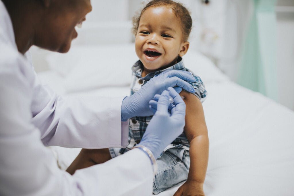 Toddler getting a vaccination by a pediatrician